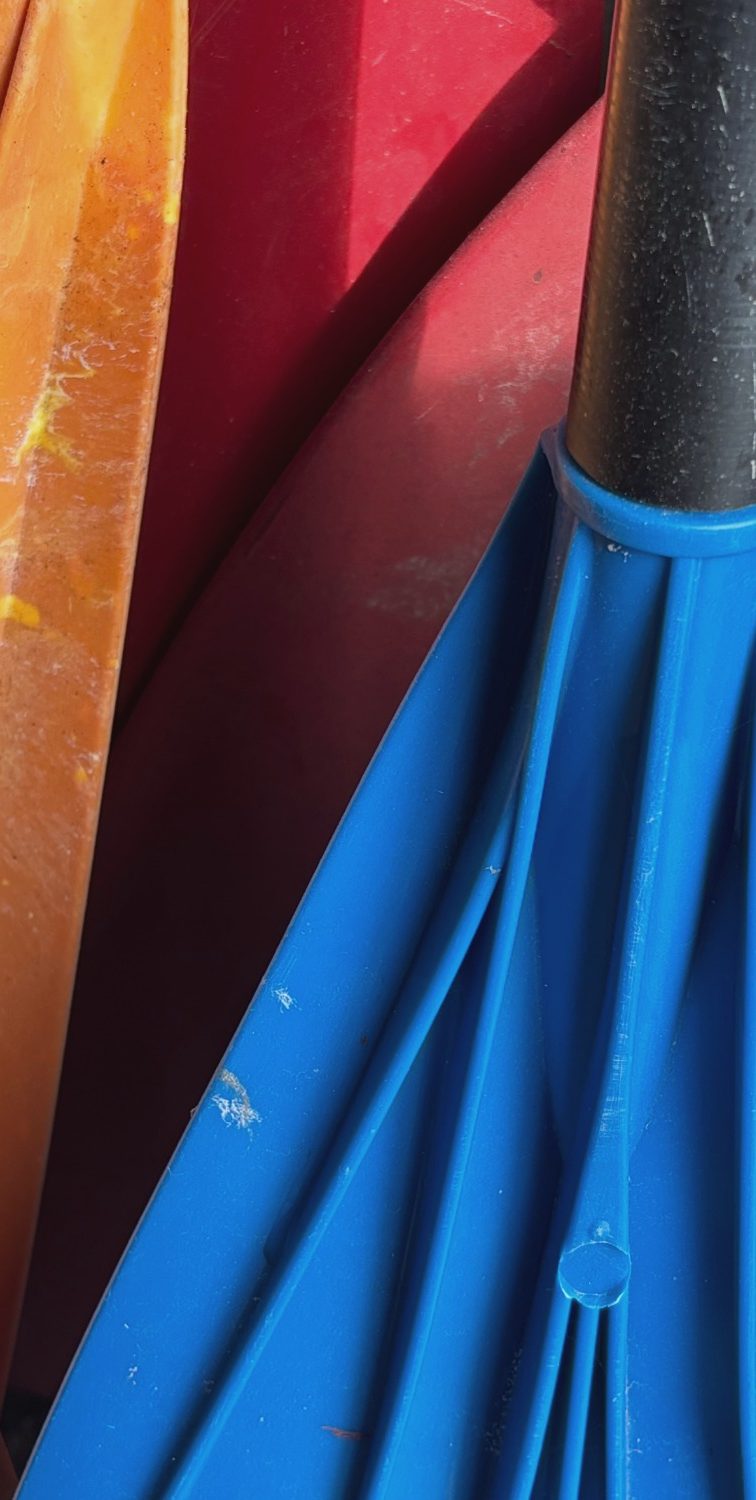Bunte Paddel Bunte Paddel in Orange, Rot und Blau, eng nebeneinander angeordnet.